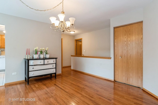20827 W Torrey Pines Ln, Plainfield, IL 60544 - empty room featuring a chandelier, light wood-type flooring, and baseboards