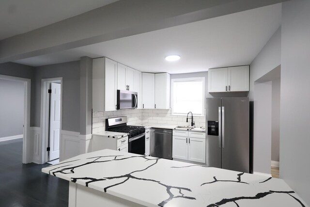 10817 S Eberhart Ave, Chicago, IL 60628 - kitchen featuring appliances with stainless steel finishes, white cabinetry, backsplash, light countertops, and a sink