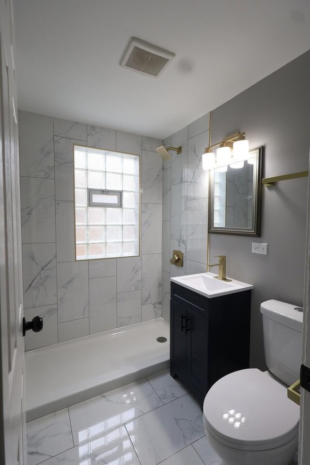 10817 S Eberhart Ave, Chicago, IL 60628 - bathroom featuring marble look tiles, a shower stall, vanity, and toilet