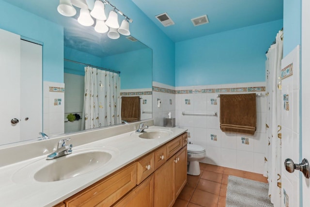 2007 S Kristina Ln, Round Lake, IL 60073 - full bath with tile patterned floors, toilet, double vanity, tile walls, and a wainscoted wall
