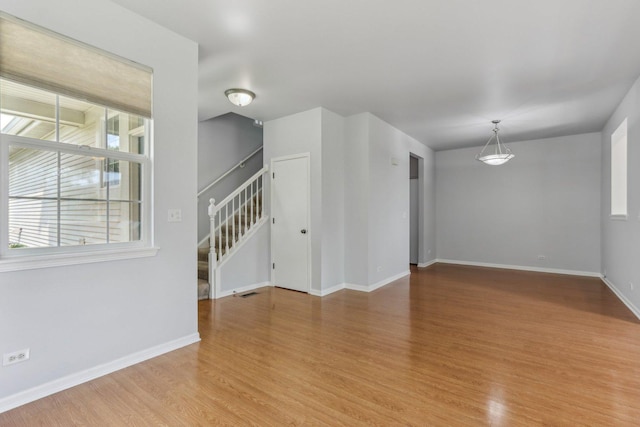 2007 S Kristina Ln, Round Lake, IL 60073 - unfurnished room with stairs, light wood-style flooring, and baseboards