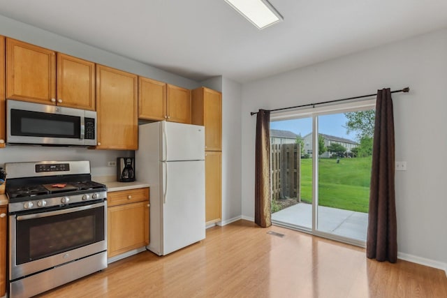 2007 S Kristina Ln, Round Lake, IL 60073 - kitchen featuring appliances with stainless steel finishes, light wood-style floors, baseboards, and light countertops