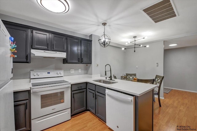 5400 Walnut Ave Unit 215, Downers Grove, IL 60515 - kitchen with white appliances, range hood, a sink, a peninsula, and a chandelier