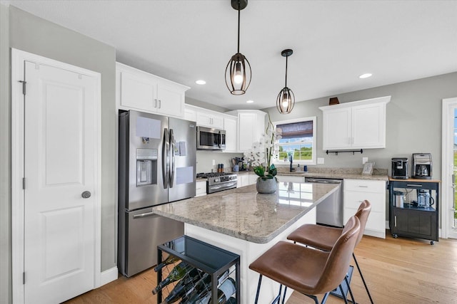7 Connor Ct, Monticello, IL 61856 - kitchen with appliances with stainless steel finishes, a sink, white cabinets, light wood-type flooring, and a center island