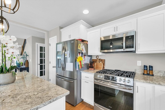 7 Connor Ct, Monticello, IL 61856 - kitchen featuring appliances with stainless steel finishes, white cabinetry, light wood finished floors, light stone counters, and recessed lighting