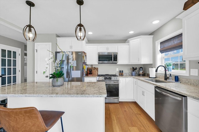 7 Connor Ct, Monticello, IL 61856 - kitchen featuring stainless steel appliances, a sink, light wood-type flooring, white cabinets, and a breakfast bar area