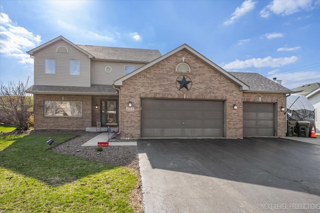 227 Wolverine Dr, Oswego, IL 60543 - view of front of home with an attached garage, brick siding, asphalt driveway, a front lawn, and a shingled roof