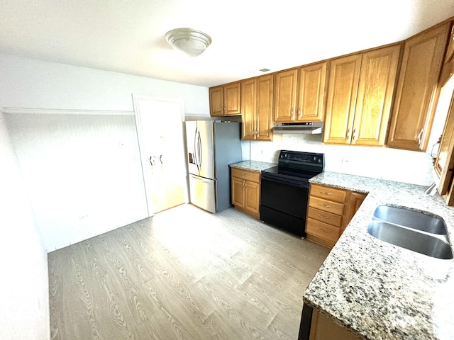 kitchen featuring black range with electric stovetop, stainless steel fridge, light wood-style flooring, a sink, and under cabinet range hood