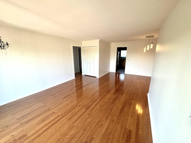 spare room featuring wood finished floors and baseboards