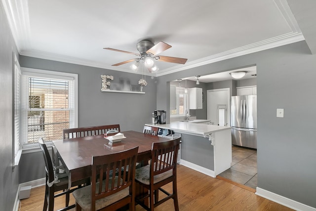 3156 W 100th St, Evergreen Park, IL 60805 - dining room featuring a ceiling fan, healthy amount of natural light, ornamental molding, light wood-style floors, and baseboards