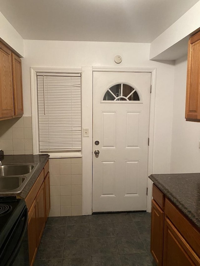 808 Bellwood Ave Unit 1N, Bellwood, IL 60104 - kitchen featuring dark countertops, brown cabinetry, a sink, dark tile patterned flooring, and black electric range