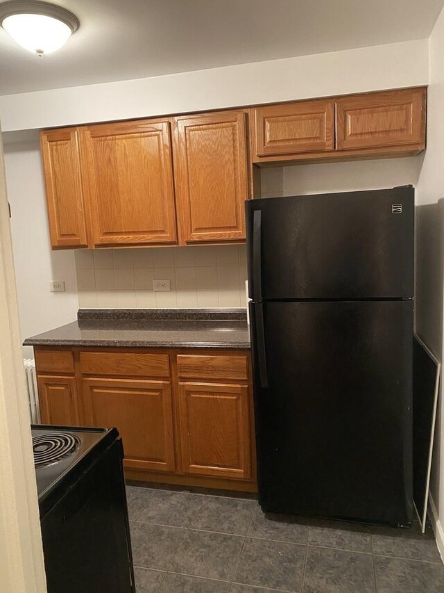 808 Bellwood Ave Unit 1N, Bellwood, IL 60104 - kitchen featuring black appliances, dark countertops, brown cabinets, and tasteful backsplash