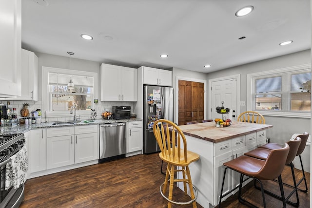 8320 Latrobe Ave, Burbank, IL 60459 - kitchen featuring appliances with stainless steel finishes, a sink, wooden counters, a kitchen breakfast bar, and tasteful backsplash