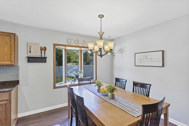 dining area with a chandelier, baseboards, and dark wood-style flooring