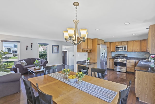 dining space featuring a chandelier, dark wood finished floors, and recessed lighting