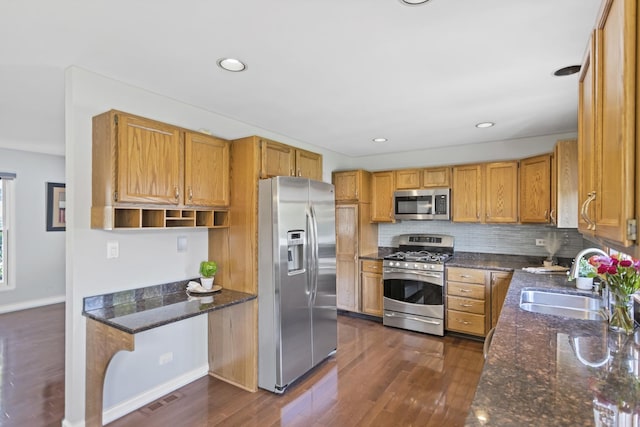 kitchen with stainless steel appliances, a sink, dark wood-style floors, decorative backsplash, and recessed lighting