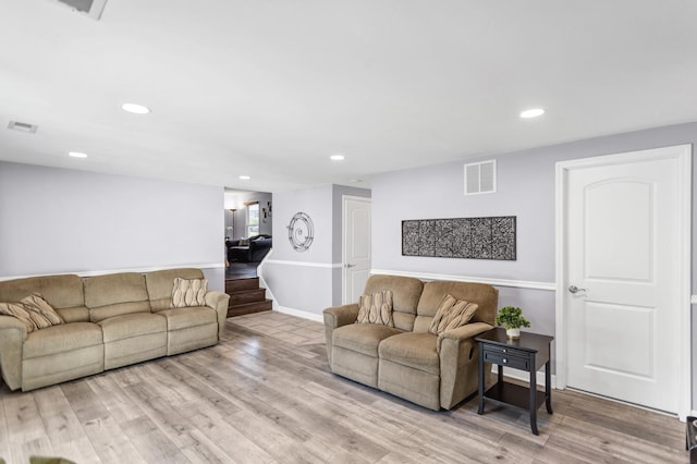 living room featuring baseboards, wood finished floors, and recessed lighting
