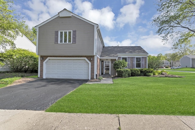 view of front of house with brick siding, asphalt driveway, a front yard, and a garage