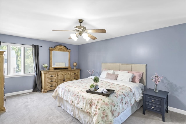 carpeted bedroom with baseboards and a ceiling fan