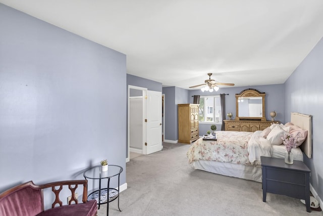 bedroom featuring baseboards, light colored carpet, and ceiling fan