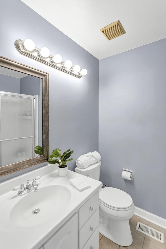 full bathroom with tile patterned floors, vanity, toilet, and a shower with shower door