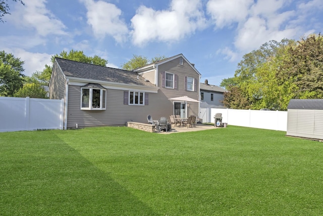 back of house featuring a storage shed, a patio, an outbuilding, and roof with shingles