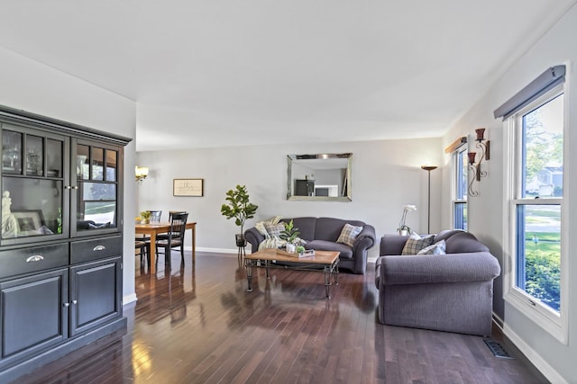 living room featuring plenty of natural light, dark wood-style flooring, and baseboards