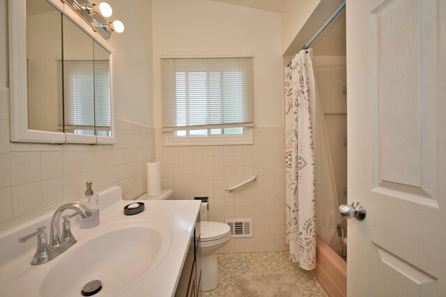 7906 Churchill St, Morton Grove, IL 60053 - bathroom featuring tile walls, tile patterned flooring, toilet, vanity, and shower / bathtub combination with curtain