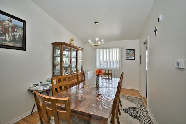 7906 Churchill St, Morton Grove, IL 60053 - dining area with a chandelier, light wood finished floors, baseboards, and vaulted ceiling