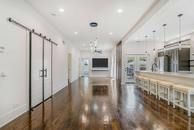 939 N Massasoit Ave, Chicago, IL 60651 - kitchen featuring freestanding refrigerator, a barn door, dark wood-style flooring, and recessed lighting