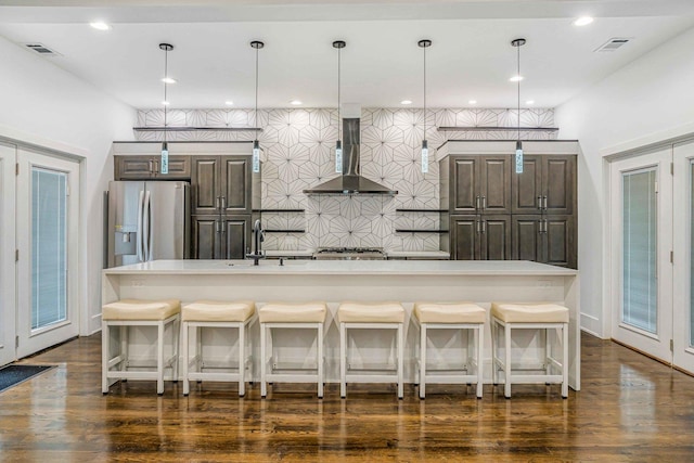 939 N Massasoit Ave, Chicago, IL 60651 - kitchen with wall chimney range hood, stainless steel fridge with ice dispenser, dark brown cabinetry, a sink, and light countertops