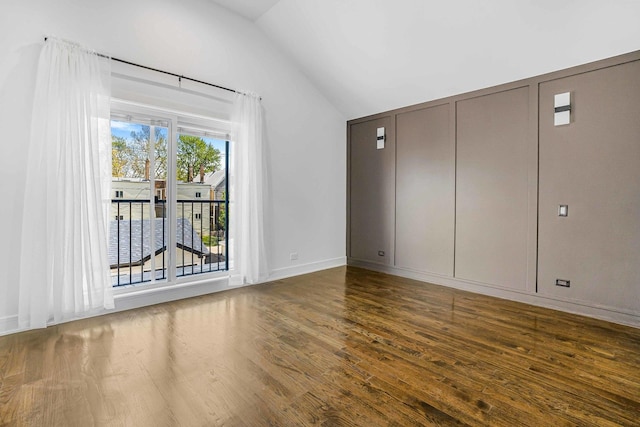 939 N Massasoit Ave, Chicago, IL 60651 - unfurnished bedroom with vaulted ceiling, wood finished floors, baseboards, and access to exterior