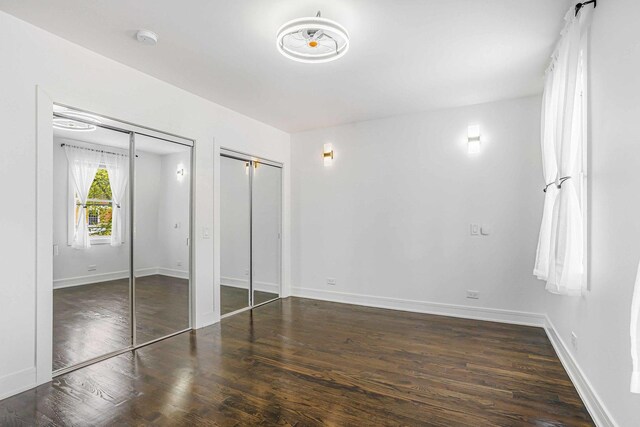 939 N Massasoit Ave, Chicago, IL 60651 - unfurnished bedroom with multiple closets, wood finished floors, and baseboards