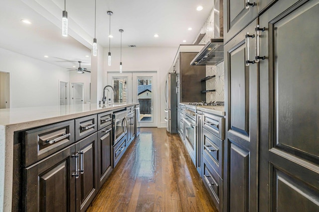 939 N Massasoit Ave, Chicago, IL 60651 - kitchen featuring a sink, stainless steel appliances, dark wood-type flooring, an island with sink, and a ceiling fan