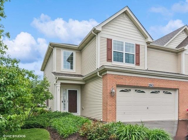 190 Birch Ln, Saint Charles, IL 60175 - view of front facade with an attached garage, brick siding, and driveway