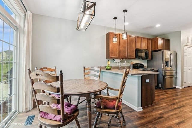 190 Birch Ln, Saint Charles, IL 60175 - kitchen featuring black microwave, stainless steel refrigerator with ice dispenser, a peninsula, range with gas stovetop, and dark wood finished floors