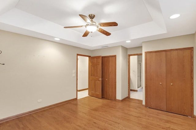 5301 S Mobile Ave, Chicago, IL 60638 - unfurnished bedroom with a raised ceiling, multiple closets, light wood-type flooring, baseboards, and recessed lighting