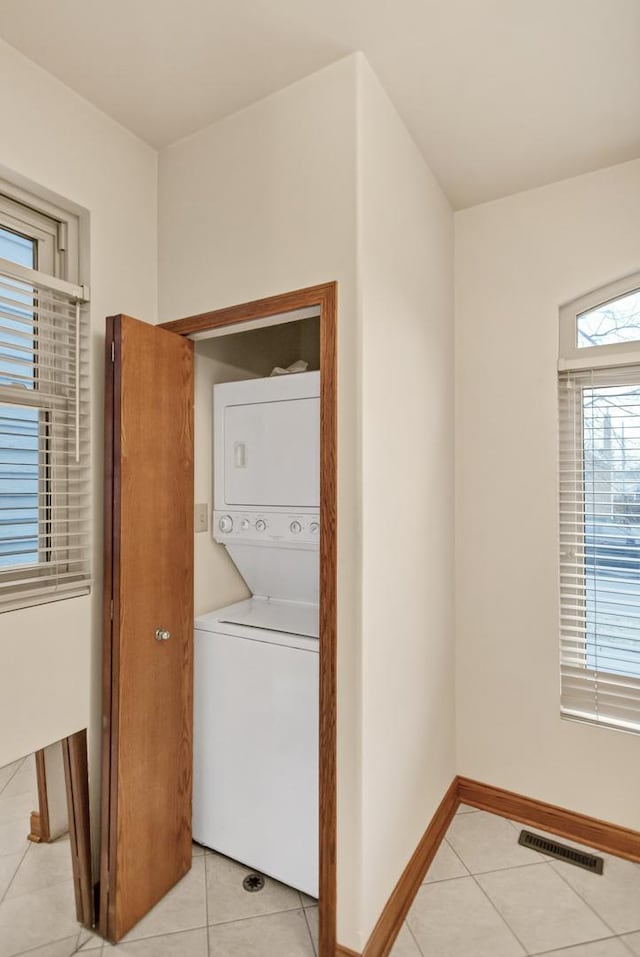 5301 S Mobile Ave, Chicago, IL 60638 - clothes washing area with stacked washing machine and dryer, light tile patterned floors, and baseboards