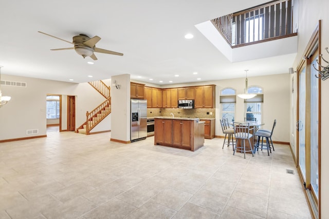 5301 S Mobile Ave, Chicago, IL 60638 - kitchen with appliances with stainless steel finishes, ceiling fan, light countertops, backsplash, and brown cabinetry