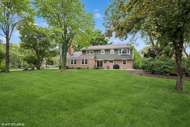25 Lagoon Dr, Hawthorn Woods, IL 60047 - back of property with a lawn, a chimney, and brick siding