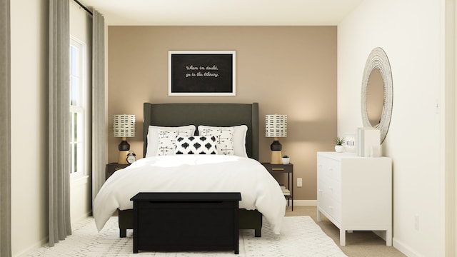 bedroom with baseboards and light carpet