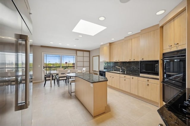 1700 2nd St Unit 509, Highland Park, IL 60035 - kitchen with light brown cabinetry, black appliances, a skylight, a center island, and decorative backsplash