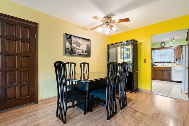 dining space with ceiling fan, light wood-style flooring, and baseboards