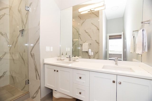 bathroom featuring a marble finish shower and double vanity