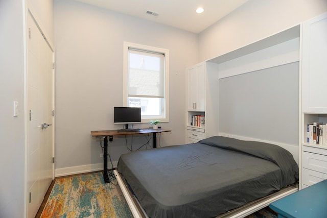 bedroom featuring baseboards, wood finished floors, and recessed lighting