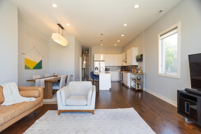 living area featuring dark wood finished floors, recessed lighting, and baseboards
