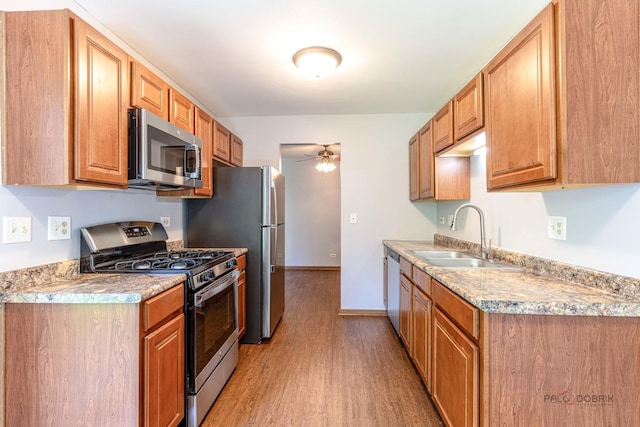 2442 Charleston Dr Unit 5, Schaumburg, IL 60193 - kitchen featuring appliances with stainless steel finishes, a sink, light wood-style flooring, a ceiling fan, and light countertops