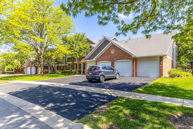 2442 Charleston Dr Unit 5, Schaumburg, IL 60193 - view of front of property featuring brick siding, asphalt driveway, a front yard, a garage, and a shingled roof