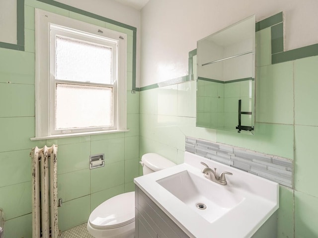 1745 E 85th St, Chicago, IL 60617 - bathroom featuring tile walls, radiator, toilet, and vanity