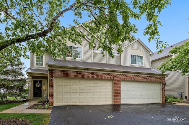 239 Nicole Dr Unit A, South Elgin, IL 60177 - traditional home featuring asphalt driveway, an attached garage, and brick siding